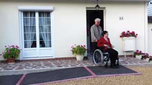 personne handicapee sur la rampe d'accès à sa maison